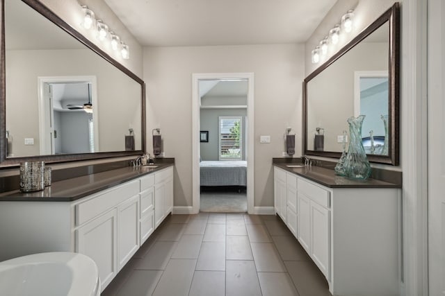 full bath featuring tile patterned flooring, two vanities, a sink, and ensuite bathroom