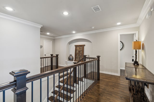 corridor with visible vents, arched walkways, dark wood-type flooring, an upstairs landing, and recessed lighting