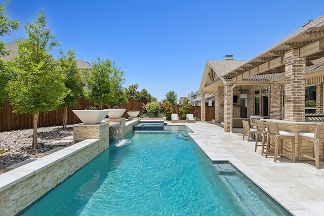 view of pool featuring a fenced in pool, outdoor dry bar, a patio area, an in ground hot tub, and a fenced backyard