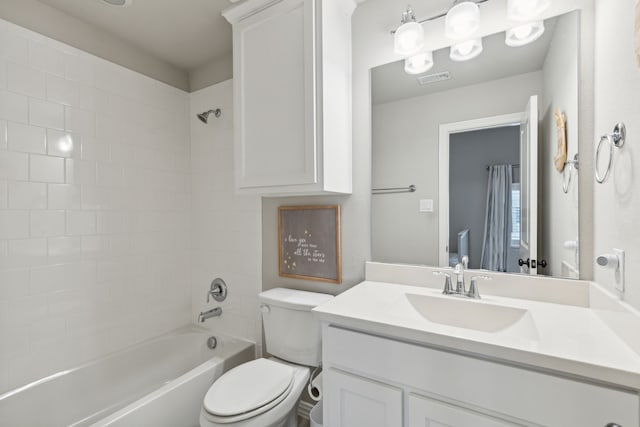 bathroom with bathtub / shower combination, visible vents, vanity, and toilet