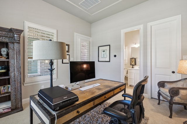 office featuring light carpet, visible vents, and baseboards