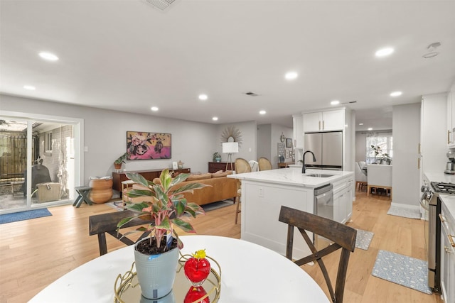 dining area with light wood-style floors, recessed lighting, and visible vents