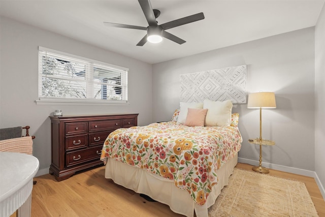 bedroom featuring a ceiling fan, light wood-style flooring, and baseboards