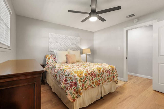 bedroom featuring light wood-type flooring, visible vents, ceiling fan, and baseboards