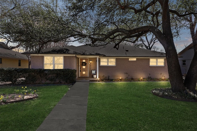 single story home with a lawn and brick siding