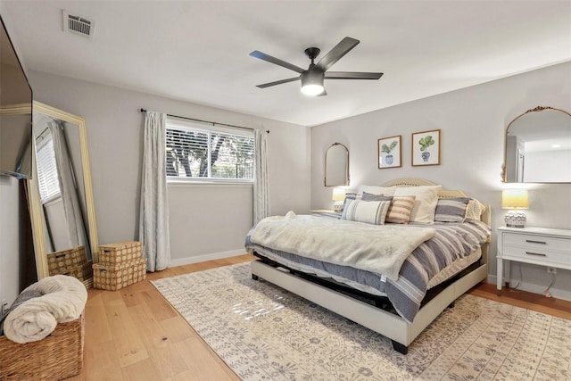 bedroom featuring light wood-type flooring, visible vents, ceiling fan, and baseboards