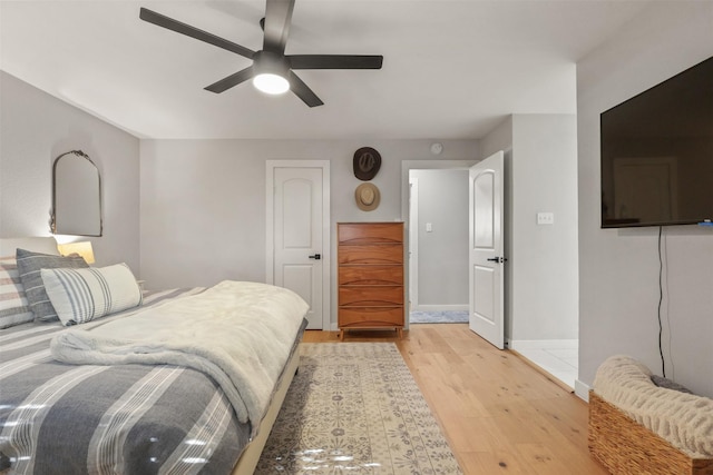 bedroom featuring light wood finished floors, ceiling fan, and baseboards