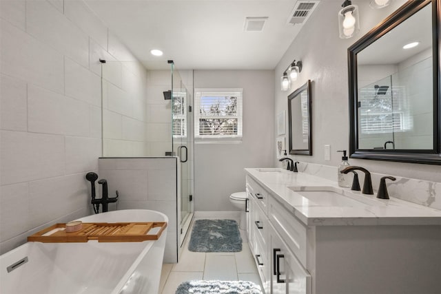 full bath with double vanity, tile patterned flooring, a shower stall, and a sink