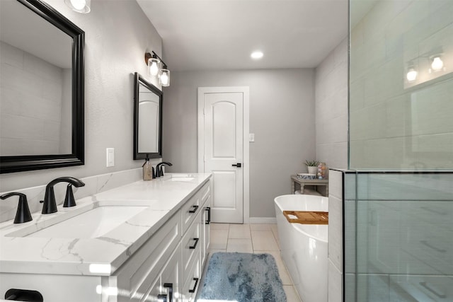 full bathroom with double vanity, tile patterned flooring, a freestanding bath, and a sink