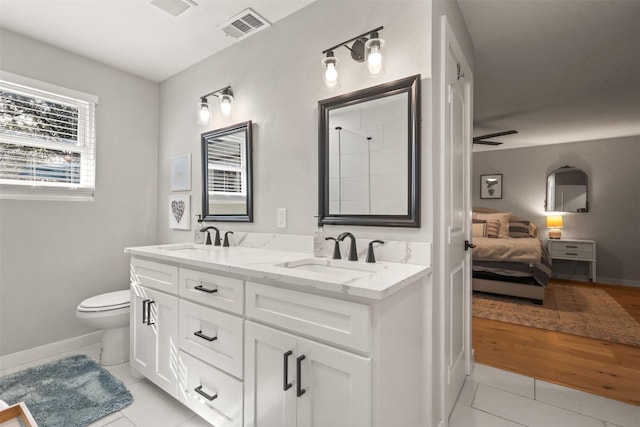 bathroom featuring toilet, a sink, visible vents, and tile patterned floors