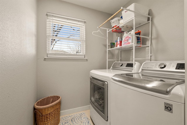 washroom with laundry area, baseboards, and washing machine and clothes dryer