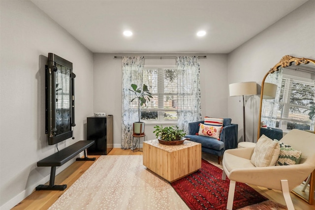 living area with light wood finished floors, baseboards, and recessed lighting