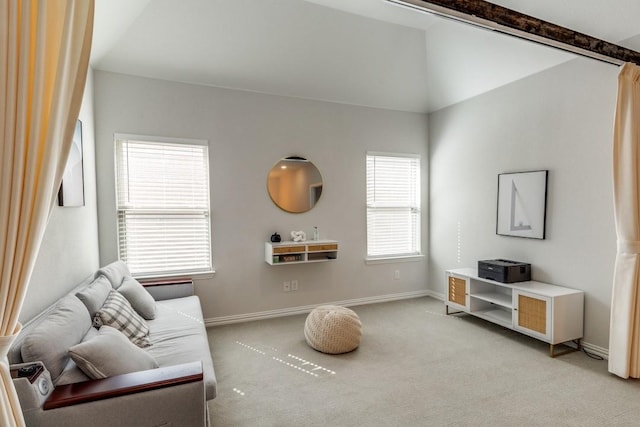 living area with light carpet, vaulted ceiling, and baseboards