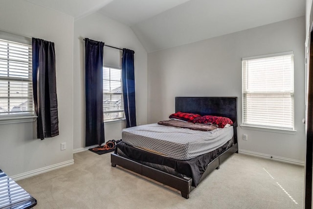 carpeted bedroom featuring lofted ceiling and baseboards