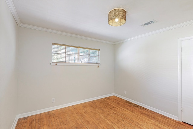 empty room featuring crown molding, light wood finished floors, visible vents, and baseboards