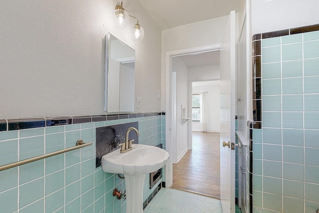 bathroom featuring wainscoting, tile patterned flooring, and tile walls