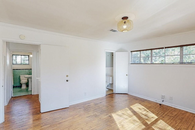 unfurnished bedroom featuring visible vents, tile walls, and wood finished floors