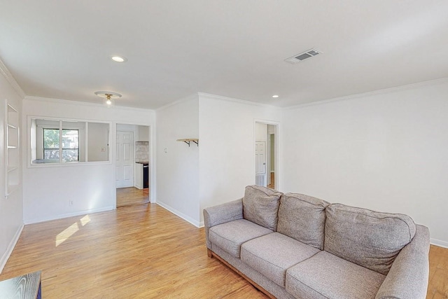 living room with recessed lighting, visible vents, ornamental molding, light wood-type flooring, and baseboards