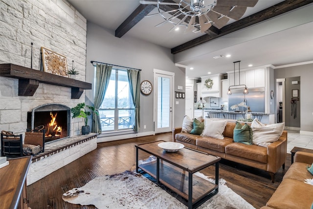 living room with ceiling fan, light wood-style flooring, a fireplace, baseboards, and beamed ceiling