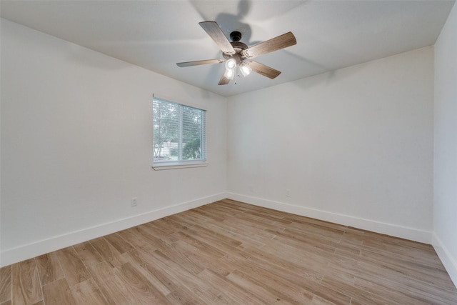 empty room with baseboards, ceiling fan, and light wood finished floors