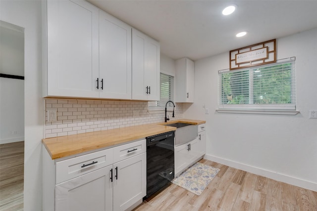 kitchen with butcher block countertops, a sink, backsplash, dishwasher, and light wood finished floors