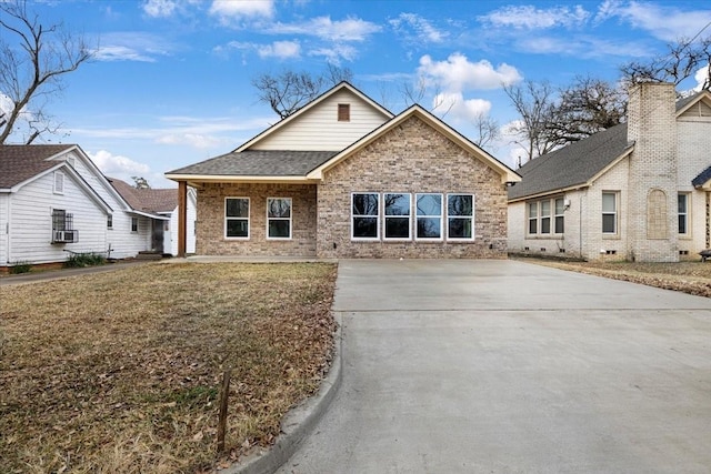 view of front of home with roof with shingles, brick siding, a front lawn, and cooling unit