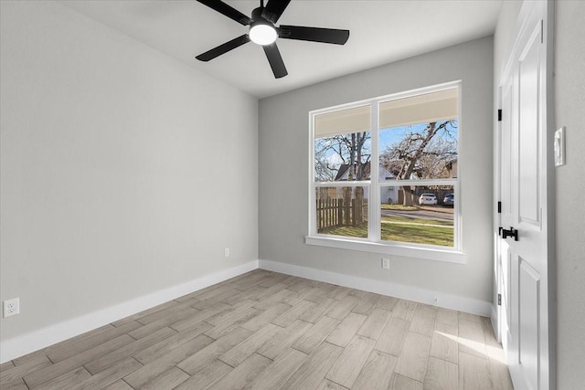 unfurnished room with a ceiling fan, baseboards, and wood finished floors