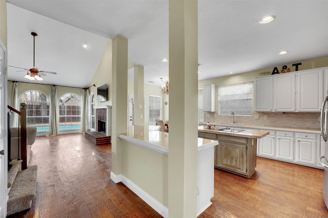 kitchen with light wood-style flooring, light countertops, decorative backsplash, and a center island