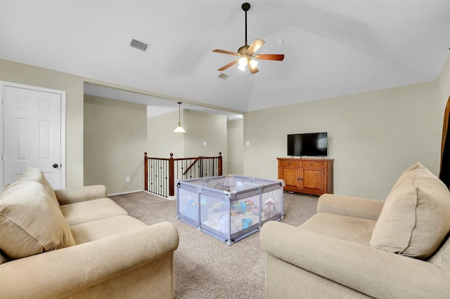 living area with visible vents, vaulted ceiling, a ceiling fan, and light colored carpet