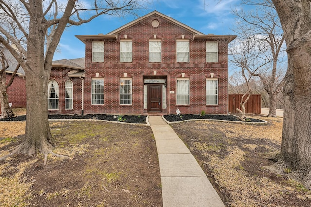 colonial-style house with brick siding and fence