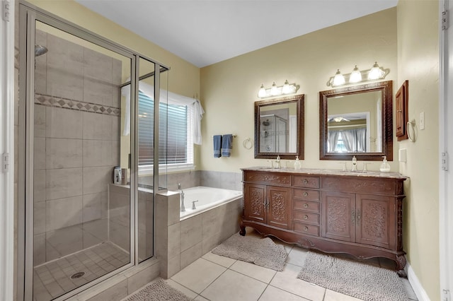 bathroom featuring double vanity, a stall shower, a bath, tile patterned floors, and a sink