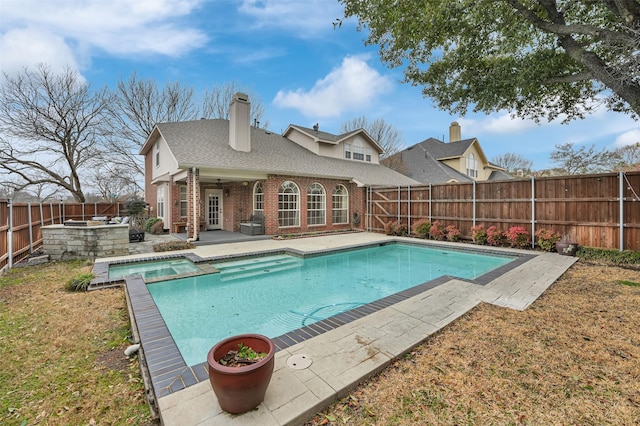 view of swimming pool featuring a patio area, a fenced backyard, and a pool with connected hot tub