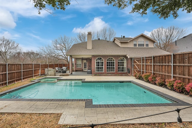 view of pool featuring a patio area, a fenced backyard, and a pool with connected hot tub