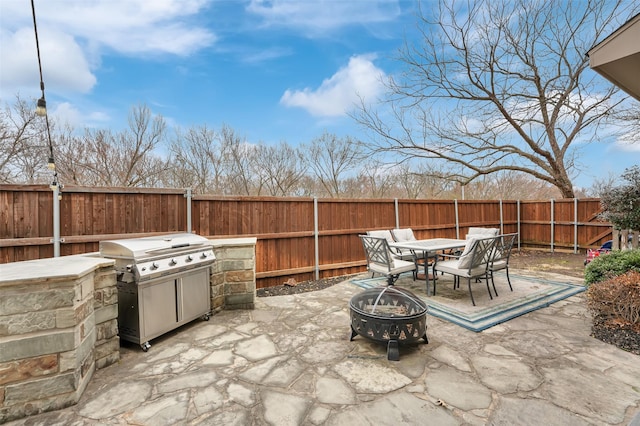 view of patio featuring an outdoor fire pit, a fenced backyard, and a grill