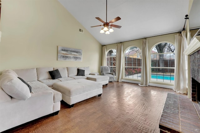 living area with high vaulted ceiling, visible vents, ceiling fan, and wood finished floors