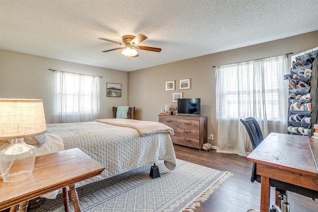 bedroom with a textured ceiling, ceiling fan, and wood finished floors