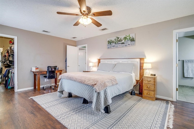 bedroom featuring a spacious closet, a closet, wood finished floors, and visible vents