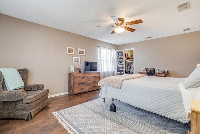 bedroom featuring visible vents, a spacious closet, and wood finished floors