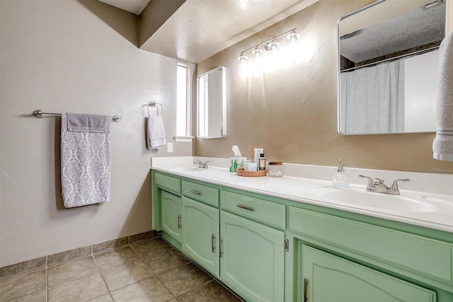 full bathroom featuring double vanity, tile patterned flooring, a sink, and baseboards