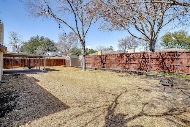 view of yard featuring a patio area, a fenced backyard, an outdoor structure, and a storage unit