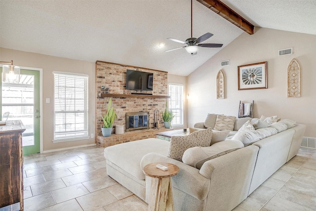 living area featuring vaulted ceiling with beams, a brick fireplace, visible vents, and a textured ceiling