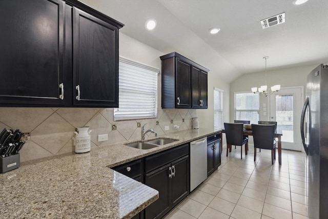 kitchen with visible vents, appliances with stainless steel finishes, vaulted ceiling, a healthy amount of sunlight, and a sink