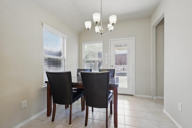 dining space with lofted ceiling, a notable chandelier, baseboards, and light tile patterned floors