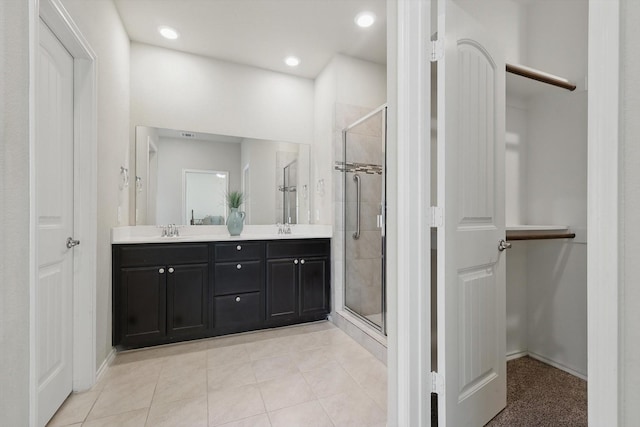 bathroom featuring double vanity, tile patterned floors, a sink, and a shower stall