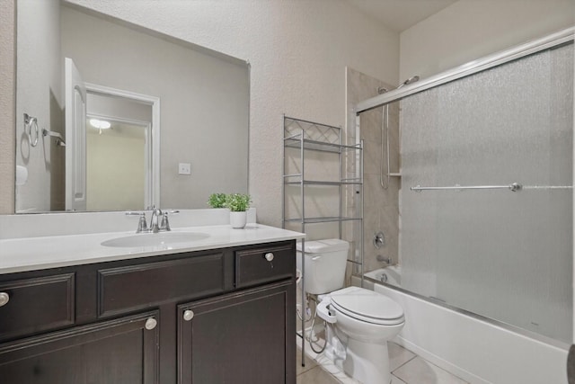 bathroom with toilet, tile patterned flooring, combined bath / shower with glass door, and vanity