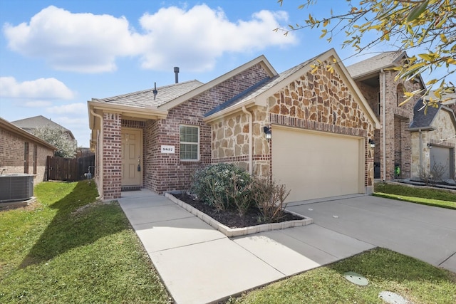 view of front of property with concrete driveway, stone siding, an attached garage, central air condition unit, and brick siding