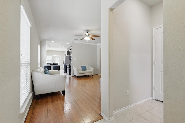 living room featuring light wood-style flooring, baseboards, ceiling fan, and recessed lighting