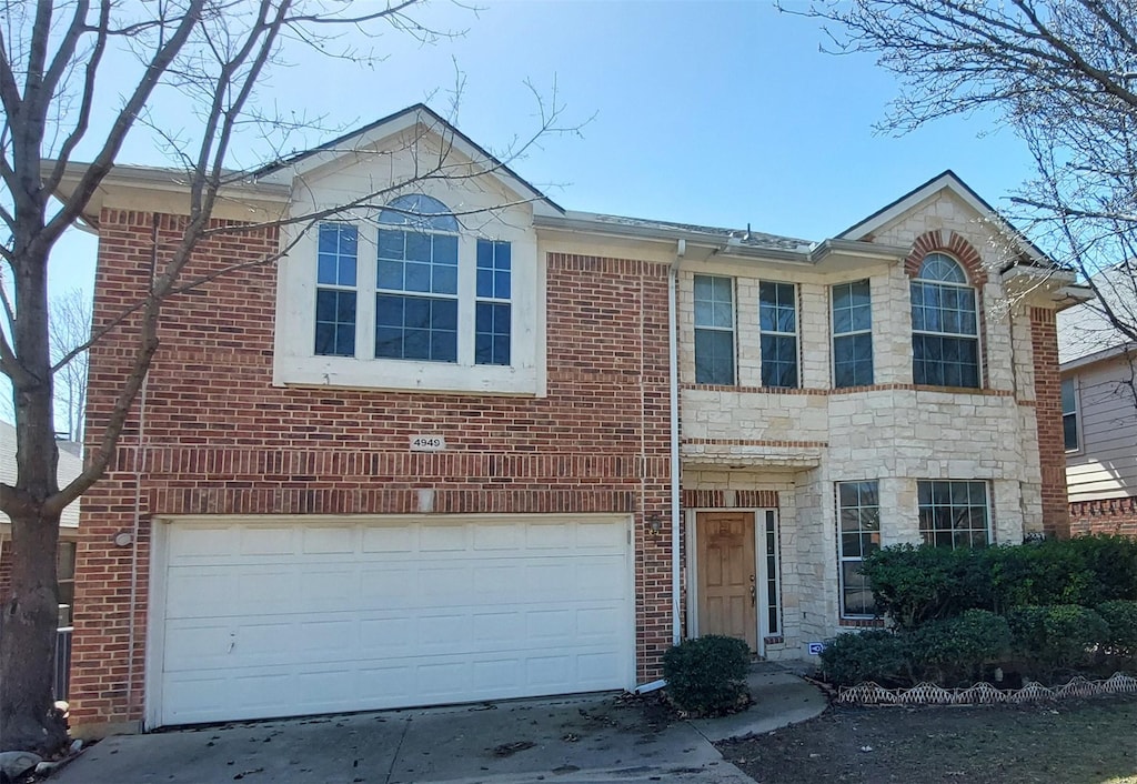 view of front of property with stone siding, concrete driveway, brick siding, and a garage