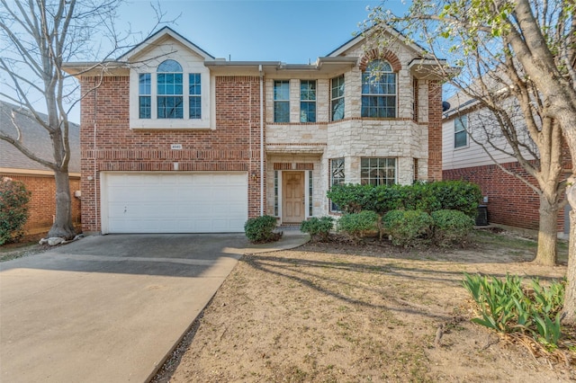 view of front of house featuring a garage, stone siding, and driveway