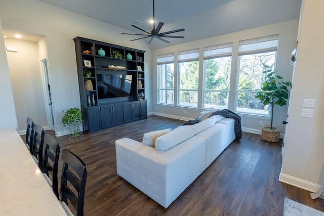 living room featuring baseboards, dark wood-type flooring, and a ceiling fan